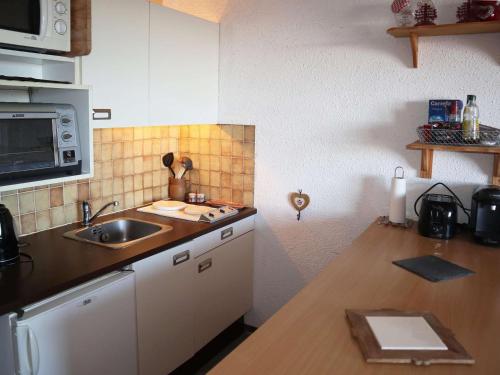 une cuisine avec un évier et un plan de travail dans l'établissement Studio pour 4 pers. aux Orres 1650, accès direct pistes - FR-1-322-551, aux Orres