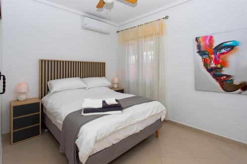a bedroom with a bed and a painting on the wall at CH Villa Aguila Ciudad Quesada in Ciudad Quesada