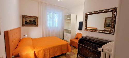 ein Schlafzimmer mit einem orangenen Bett und einem Spiegel in der Unterkunft Machiavelli Forty Seven in Rom