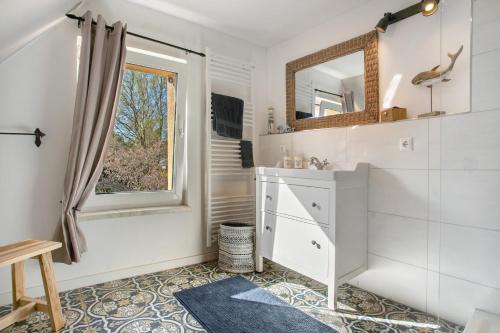 a bathroom with a sink and a mirror at Urlaub unterm Reetdach in Fuhlendorf