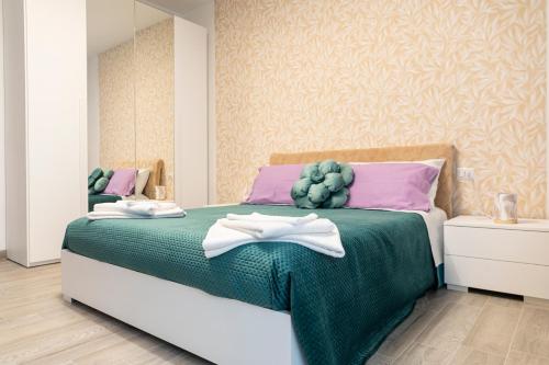 巴里Dimora serafino的一间卧室配有一张带粉色和紫色枕头的绿色床。