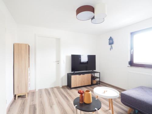 a living room with a couch and a tv at Ferienhaus im Weindorf -4 Erw 2 Ki- in Kappelrodeck