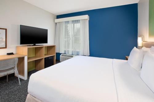 a hotel room with a bed and a tv at Spark by Hilton Walker Grand Rapids North in Grand Rapids