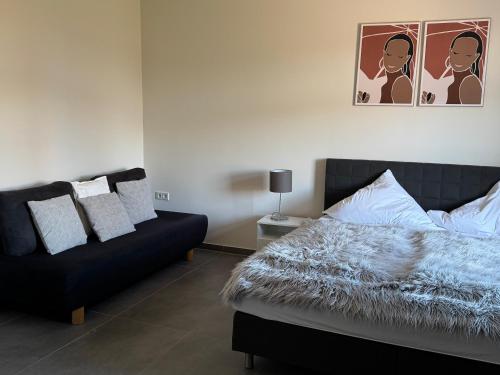 a bedroom with a bed and a couch at Pier 1 bis 4 gmütliche Zimmer mit Boxspringbett in Cuxhaven