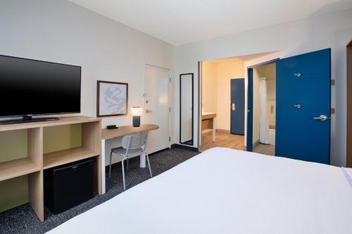a hotel room with a bed and a flat screen tv at Spark by Hilton Walker Grand Rapids North in Grand Rapids