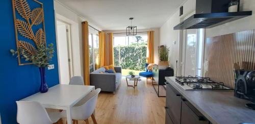 a kitchen and living room with a table and a stove at Chalet met privé tuin & hottub Zeeland VP064 in Heinkensand