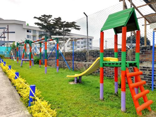 a playground with colorful playground equipment in a park at Aparthotel 2km Parque del Café BOOKUTRIP - 311-227-59-73 in Montenegro