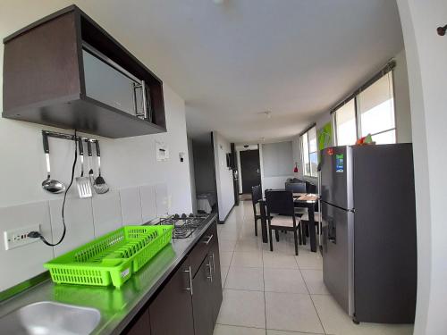 a kitchen with a sink and a refrigerator at Aparthotel 2km Parque del Café BOOKUTRIP - 311-227-59-73 in Montenegro