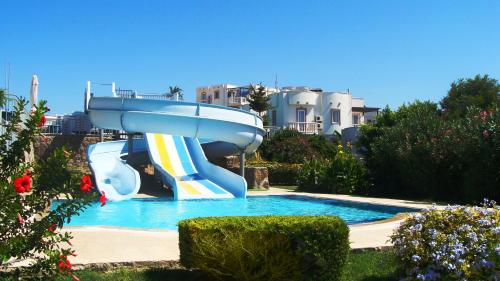 una piscina con un tobogán de agua en un patio en Yalikavak Holiday Gardens, en Yalıkavak