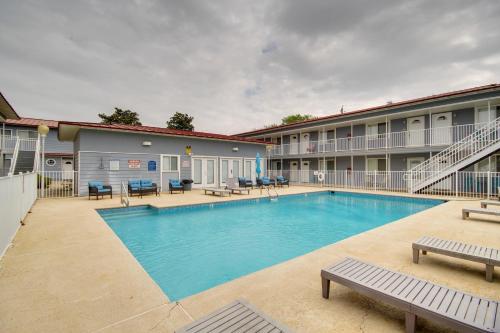 a pool at a hotel with benches and tables at Less Than Half Mi to Gulf Biloxi Condo with Patio! in Biloxi