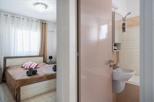 a small bathroom with a bed and a sink at Carisa flat, 2 bedrooms in Larnaca