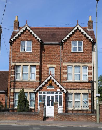 a red brick house with a white door at All Seasons Guest House in Oxford