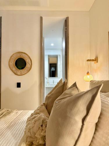 a bedroom with a bed with pillows and a mirror at Almare Apartamentos nuevos in Gustavo Rojas Pinilla International