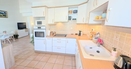 une cuisine avec des armoires blanches et un évier dans l'établissement Ref MILTON by Palmes d Or Properties, à Cannes