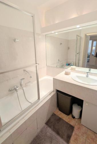 une salle de bain blanche avec une baignoire et un lavabo dans l'établissement Ref MILTON by Palmes d Or Properties, à Cannes