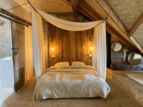 une chambre avec un grand lit à baldaquin dans l'établissement Beautiful Loft in old Barn, à Entraunes