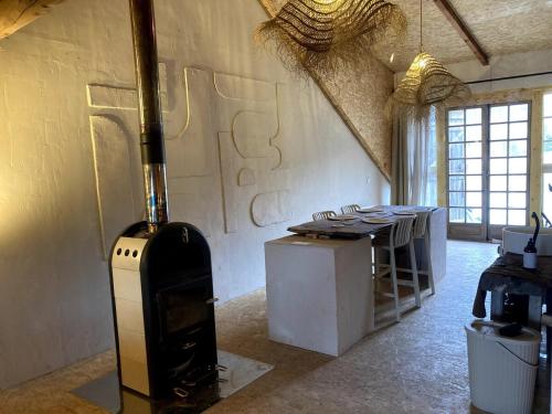 Cette chambre dispose d'une cuisinière et d'une table. dans l'établissement Beautiful Loft in old Barn, à Entraunes