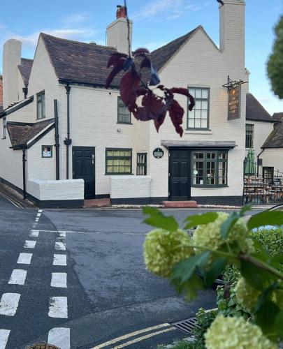 a white house with a crosswalk in front of a street at The Golden Ball Inn 1728 in Ironbridge