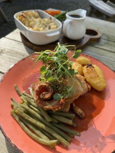 a plate of food with meat and vegetables on a table at The Golden Ball Inn 1728 in Ironbridge