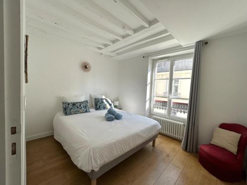 une chambre avec un lit avec un animal en peluche dessus dans l'établissement Outstanding and sunbathed 3 br, à Paris