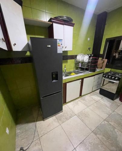 a kitchen with a refrigerator and a stove in it at Beauty home Douala ndogbong in Douala
