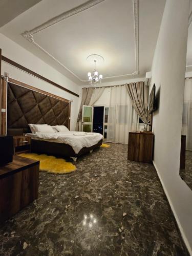 a large bedroom with a bed and a chandelier at Le conrad grand luxury hotel in Yaoundé