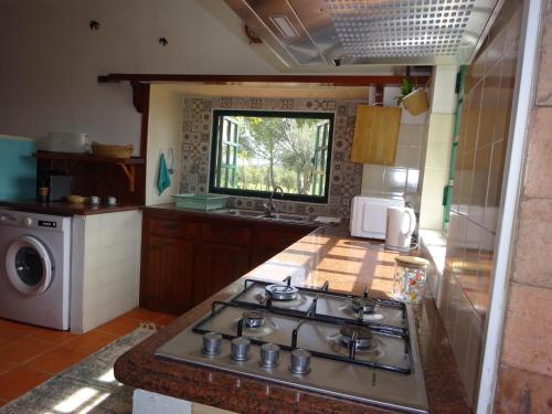 a kitchen with a stove and a sink in it at New Village in Vila Nova da Baronia