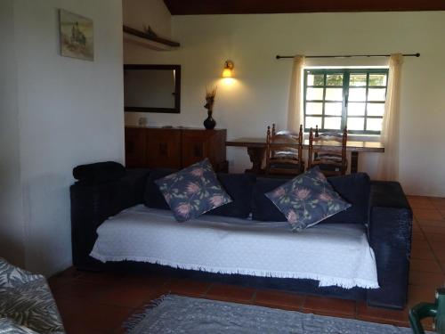 a living room with a blue couch with pillows at New Village in Vila Nova da Baronia