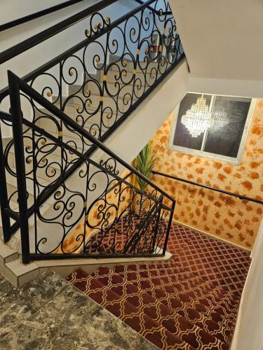 a staircase with a wrought iron railing and a rug at Le conrad grand luxury hotel in Yaoundé