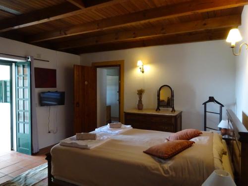 a bedroom with a large bed and a mirror at New Village in Vila Nova da Baronia