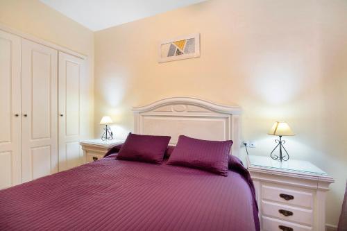 a purple bed with two purple pillows in a bedroom at Apartamento Bajamar in Sanlúcar de Barrameda