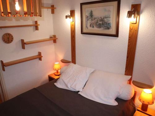 une chambre avec un lit avec deux lampes et un tableau au mur dans l'établissement Appartement 2P6 au cœur de Les Orres, proche commerces, vue vallée - FR-1-322-324, aux Orres