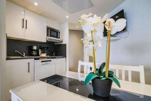 une cuisine avec une table et une plante. dans l'établissement Le Cannes Beach 799 - terrasse vue mer panoramique, à Cannes