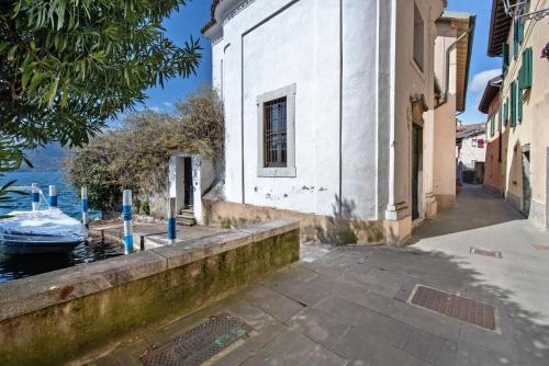 a white building with a window next to the water at Il Giardino Segreto Sulzano in Sulzano