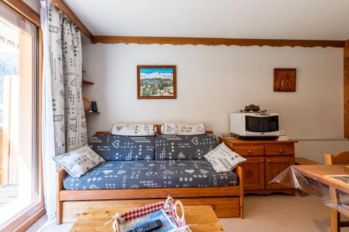 a living room with a couch and a tv at Valfréjus La montagne- App 123 in Valfréjus