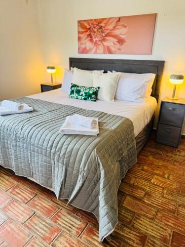 a bedroom with a large bed with two towels on it at Casa da Parreira in Loulé