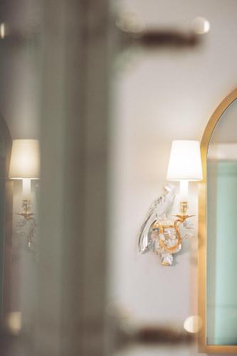 two lamps on a wall with a bird on it at Maison Barrière Vendôme in Paris