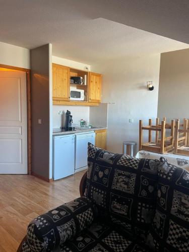 un salon avec un canapé et une cuisine dans l'établissement Appartement 6 personnes au coeur de la station Les Orres 1800m, aux Orres