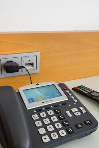 a calculator sitting on a desk next to a remote control at Daniya Alicante in Alicante