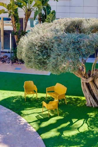 two chairs and a table and a tree at Daniya Alicante in Alicante