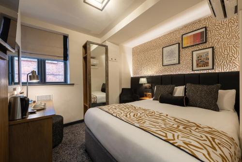 a bedroom with a large bed and a mirror at Abel Heywood Boutique Hotel in Manchester