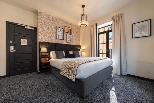 a bedroom with a large bed and a large window at Abel Heywood Boutique Hotel in Manchester