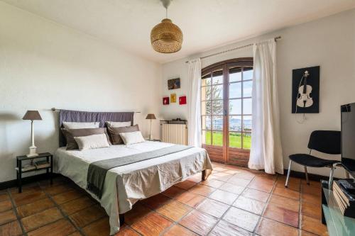 une chambre avec un lit et une grande fenêtre dans l'établissement Magnifique villa avec vue mer panoramique, à Nice