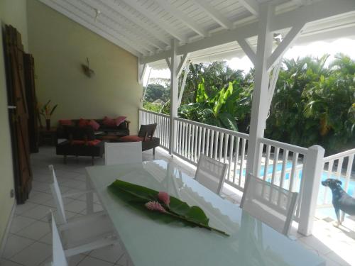 a living room with a table and a view of the ocean at La maison in Sainte-Rose