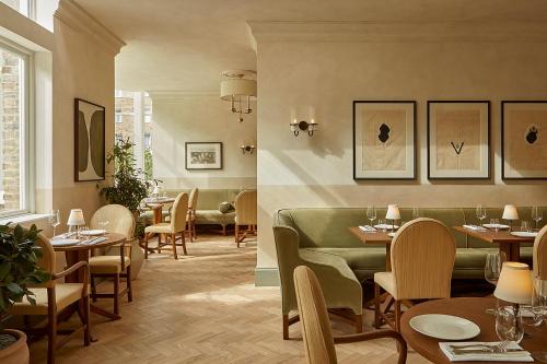 a restaurant with tables and chairs in a room at Miiro Templeton Garden in London