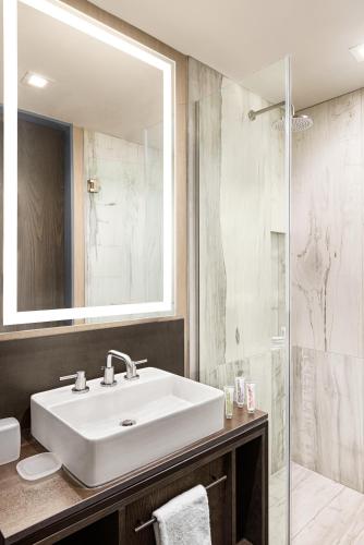 a bathroom with a white sink and a shower at Le Meridien New York, Fifth Avenue in New York