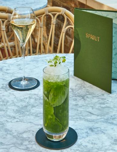 a glass of water and a glass of wine on a table at Miiro Templeton Garden in London
