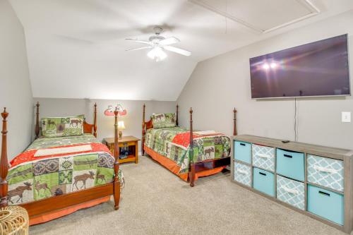 a bedroom with two beds and a flat screen tv at Game Room and Fire Pit Riverfront Home in Ellijay! in Ellijay