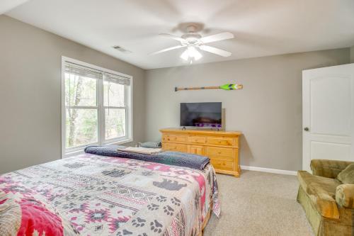 a bedroom with a bed and a flat screen tv at Game Room and Fire Pit Riverfront Home in Ellijay! in Ellijay