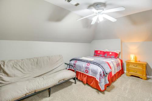 a bedroom with a bed and a couch and a ceiling fan at Game Room and Fire Pit Riverfront Home in Ellijay! in Ellijay